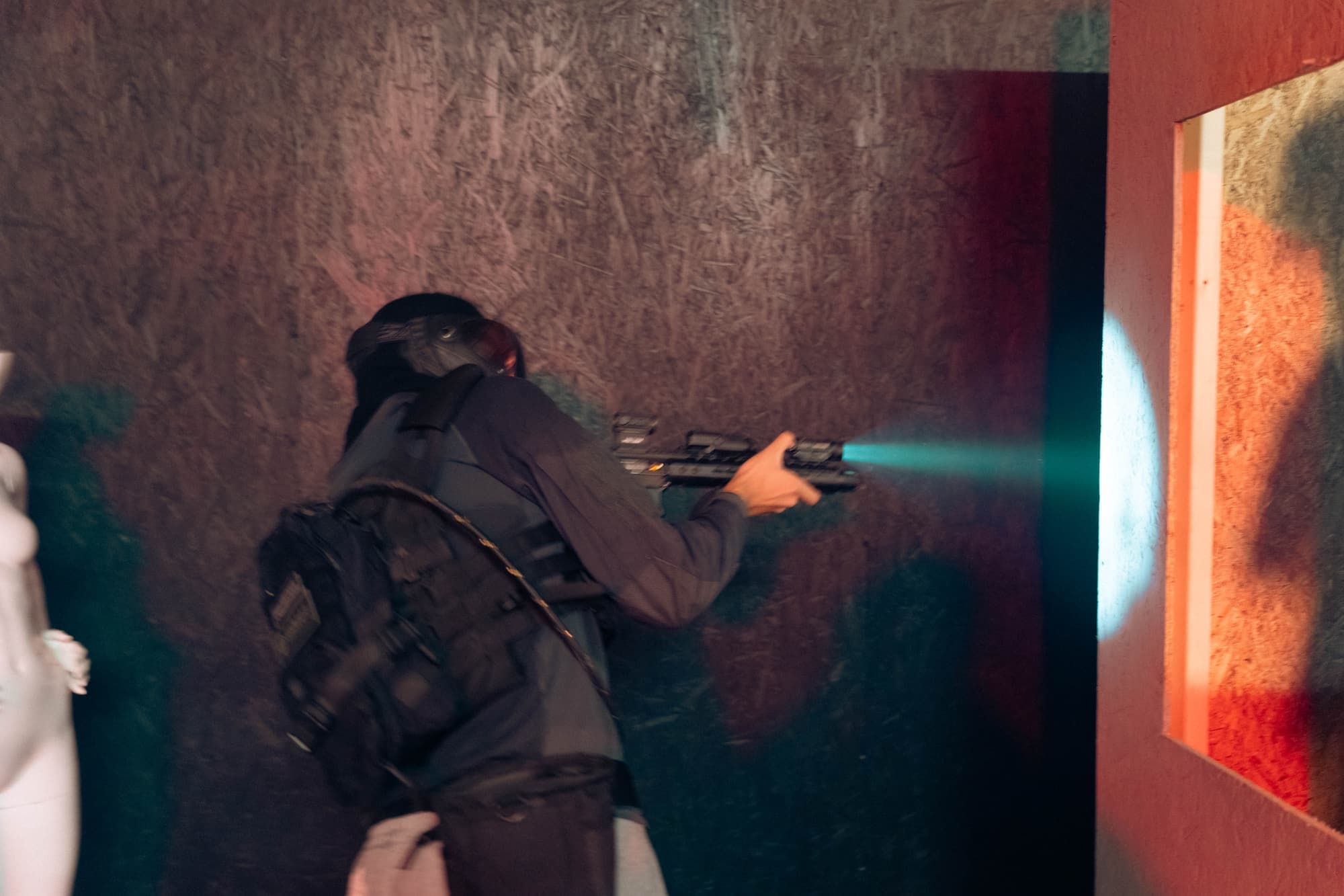 Player moving through a dark room with a weapon light on