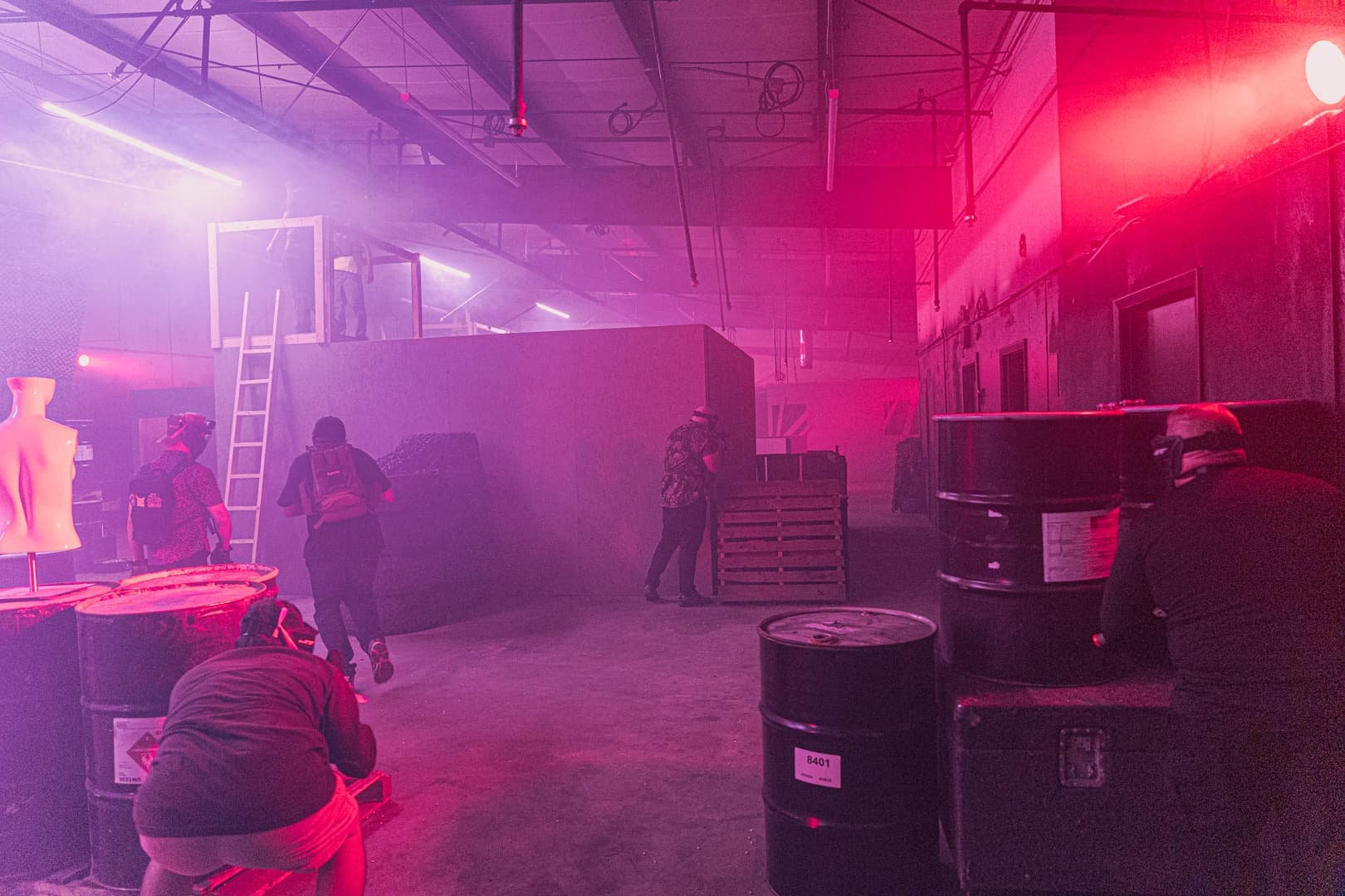 Wide view of the hazy arena with barrels, walls and a player on the move