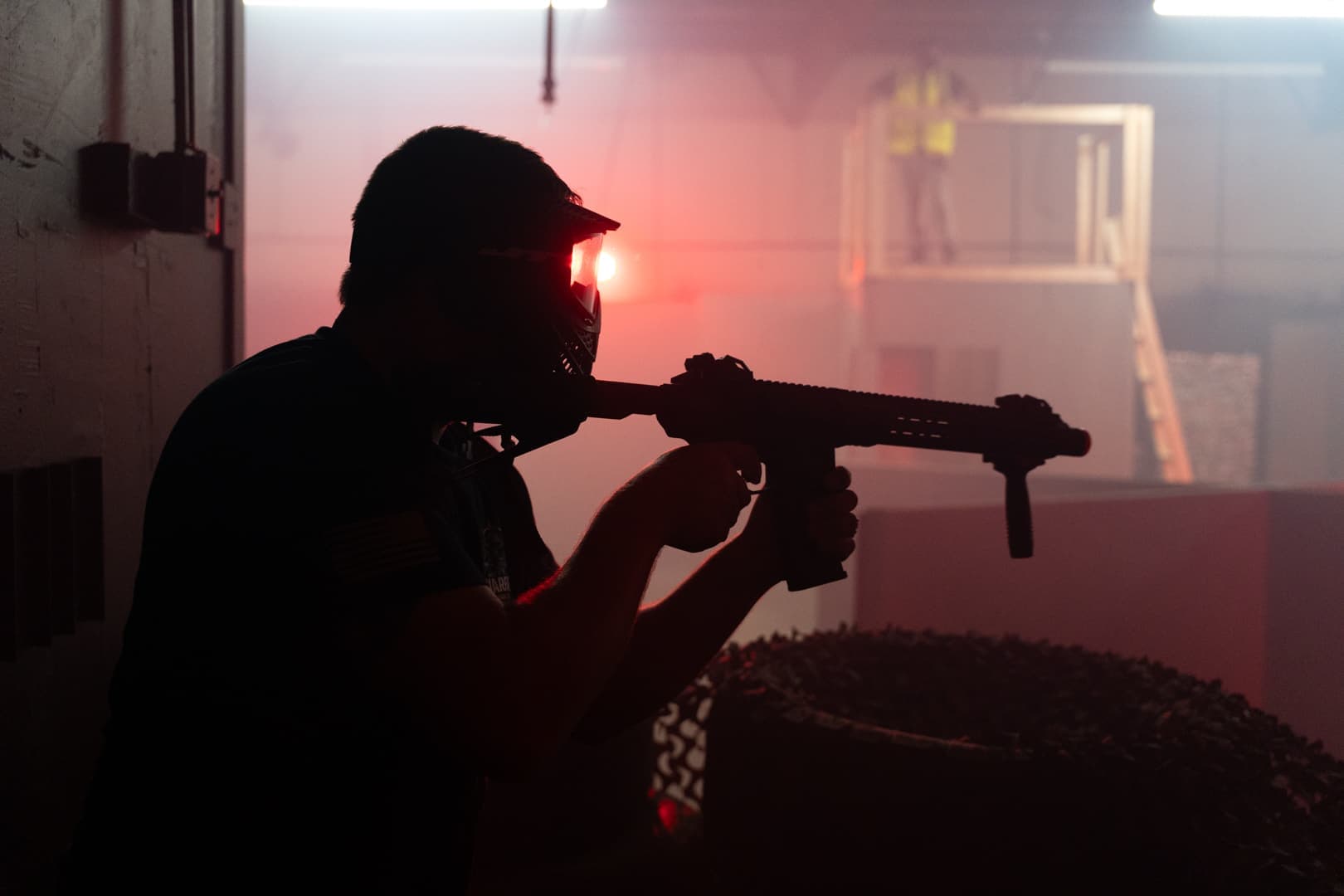 Silhouetted player aiming across a dark room