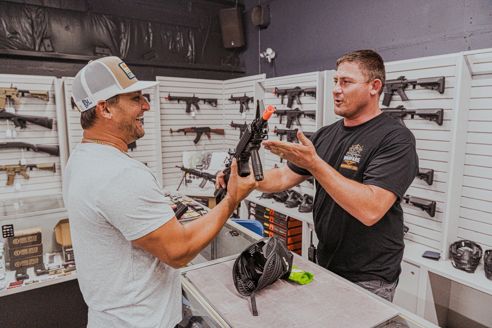 Staff member handing a rental replica to a player at the counter